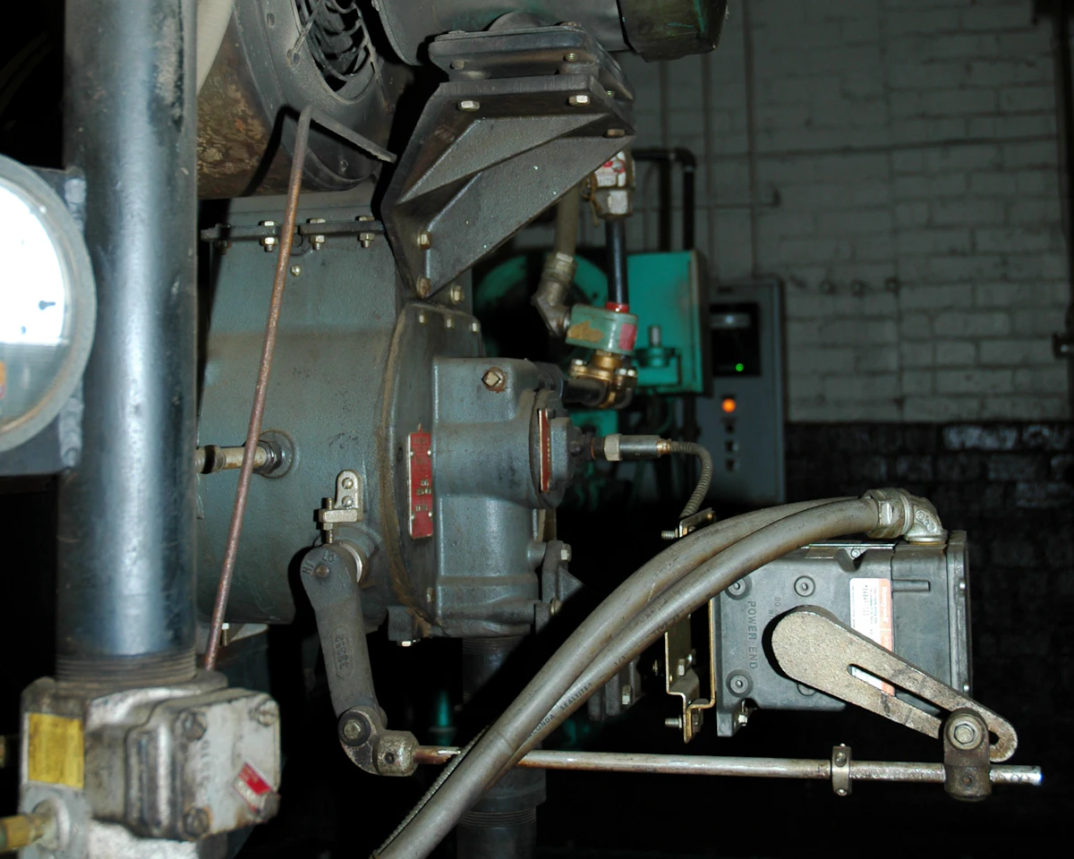 Close view of an installed generating engine with its piping and linkages in a machine room.